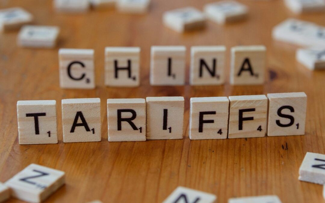 Scrabble tiles spelling “CHINA TARIFFS” on a wooden surface with scattered letters