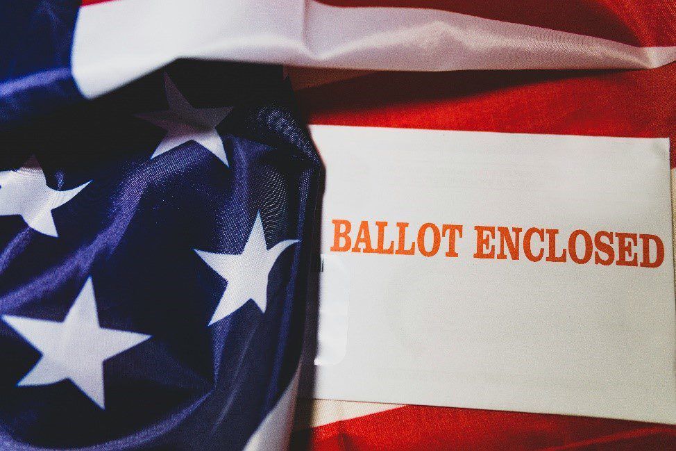 American flag with ballot enclosed text on an envelope