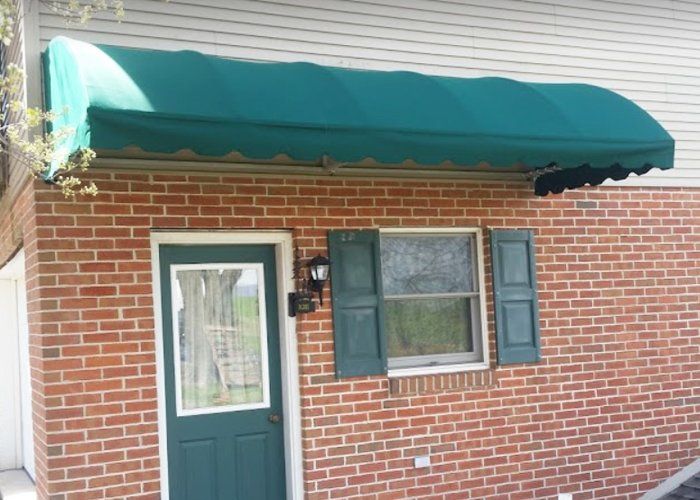 green residential door and window awning