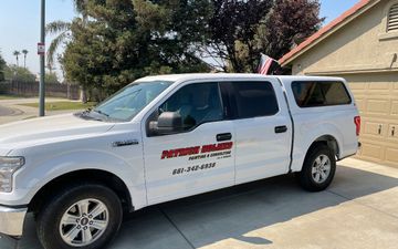 White Patrick Holmes service truck is parked in front of a house.