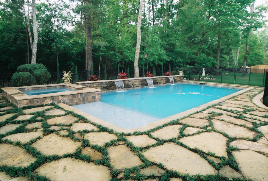 a large swimming pool surrounded by trees and rocks
