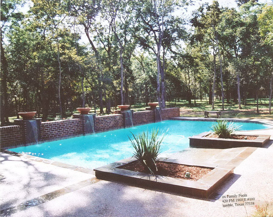 a large swimming pool with trees in the background
