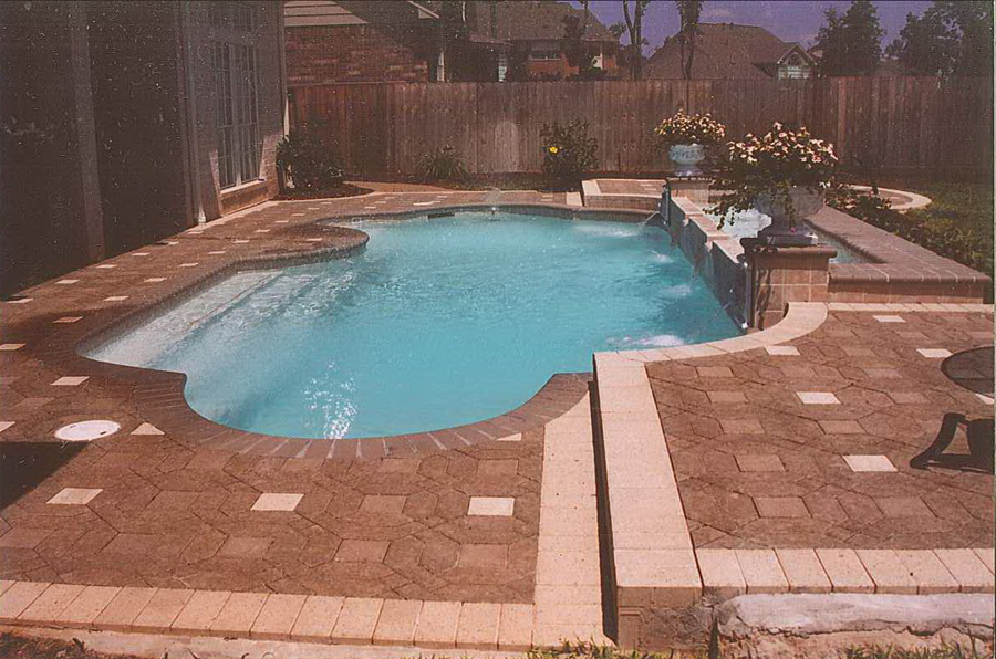 a large swimming pool is surrounded by a brick patio