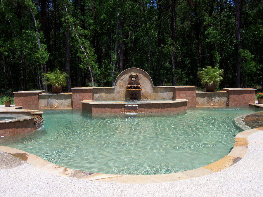 a large swimming pool with a fountain in the middle