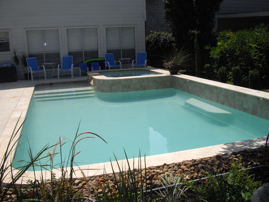 a large swimming pool is surrounded by chairs and plants