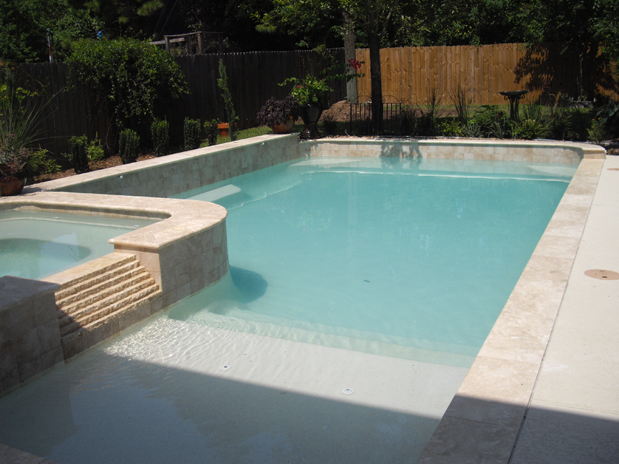 a large swimming pool with a hot tub next to it