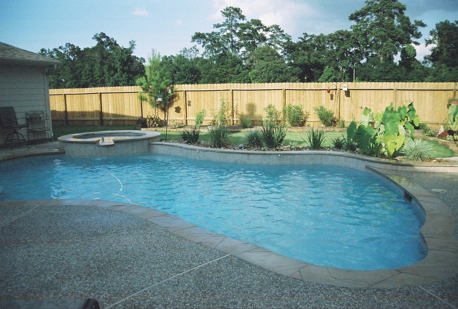 a large swimming pool with a wooden fence surrounding it