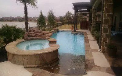 a large swimming pool with a hot tub next to it .