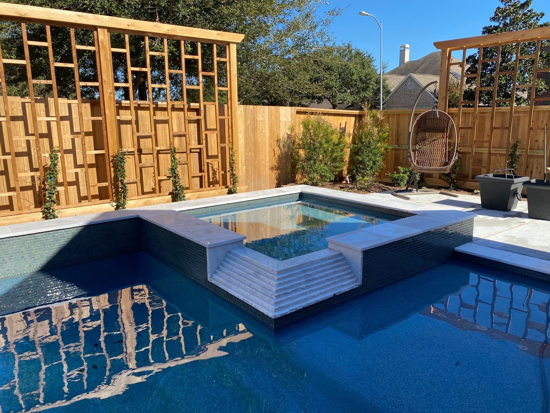 a large swimming pool with a wooden fence surrounding it