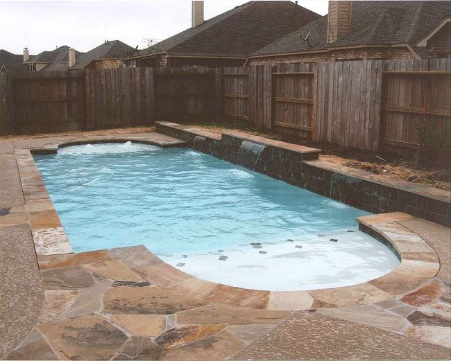 a large swimming pool with a wooden fence surrounding it