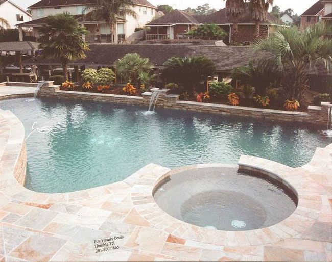 a large swimming pool with a hot tub in the middle