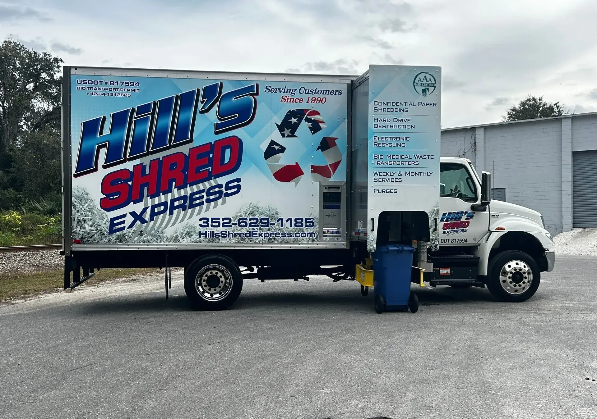 Hill's Shred Express truck. Blue and white with recycling logo. Parked outdoors.