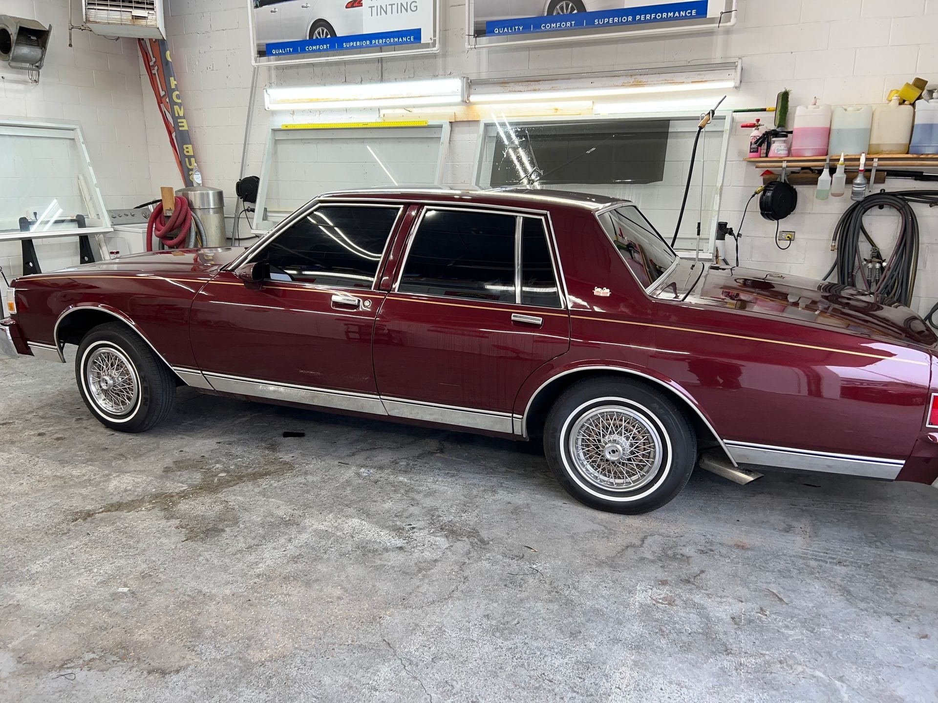 A burgundy car is parked in a garage.