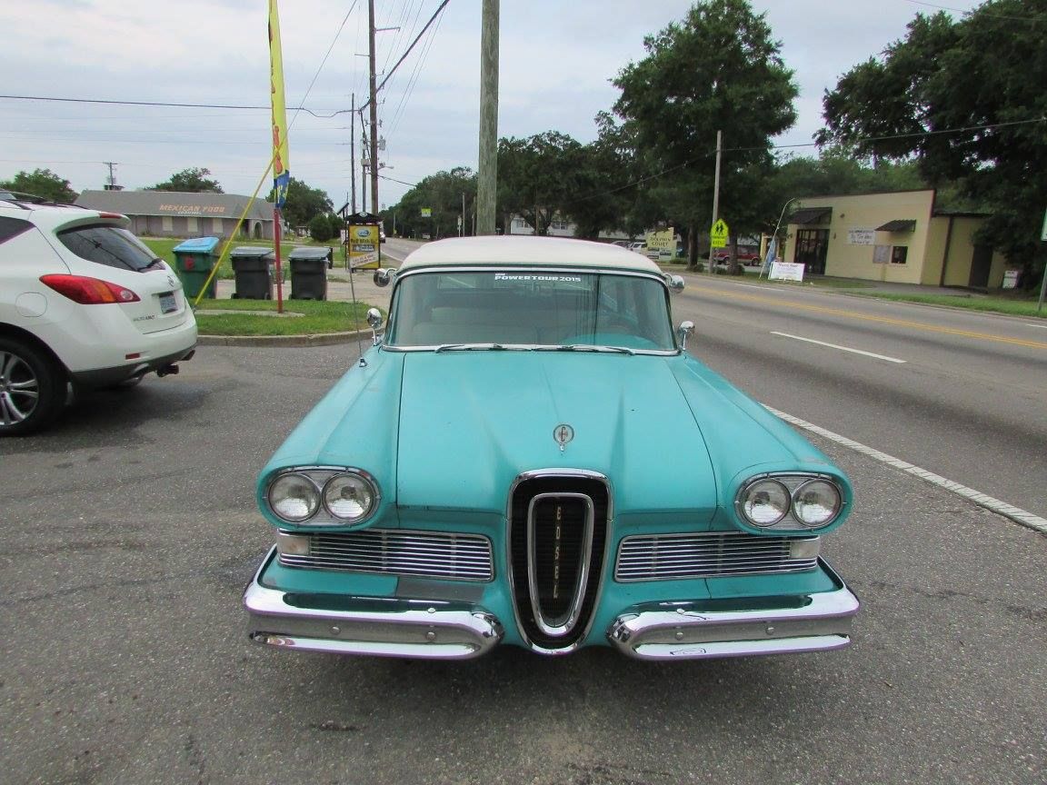 A blue and white car is parked on the side of the road.