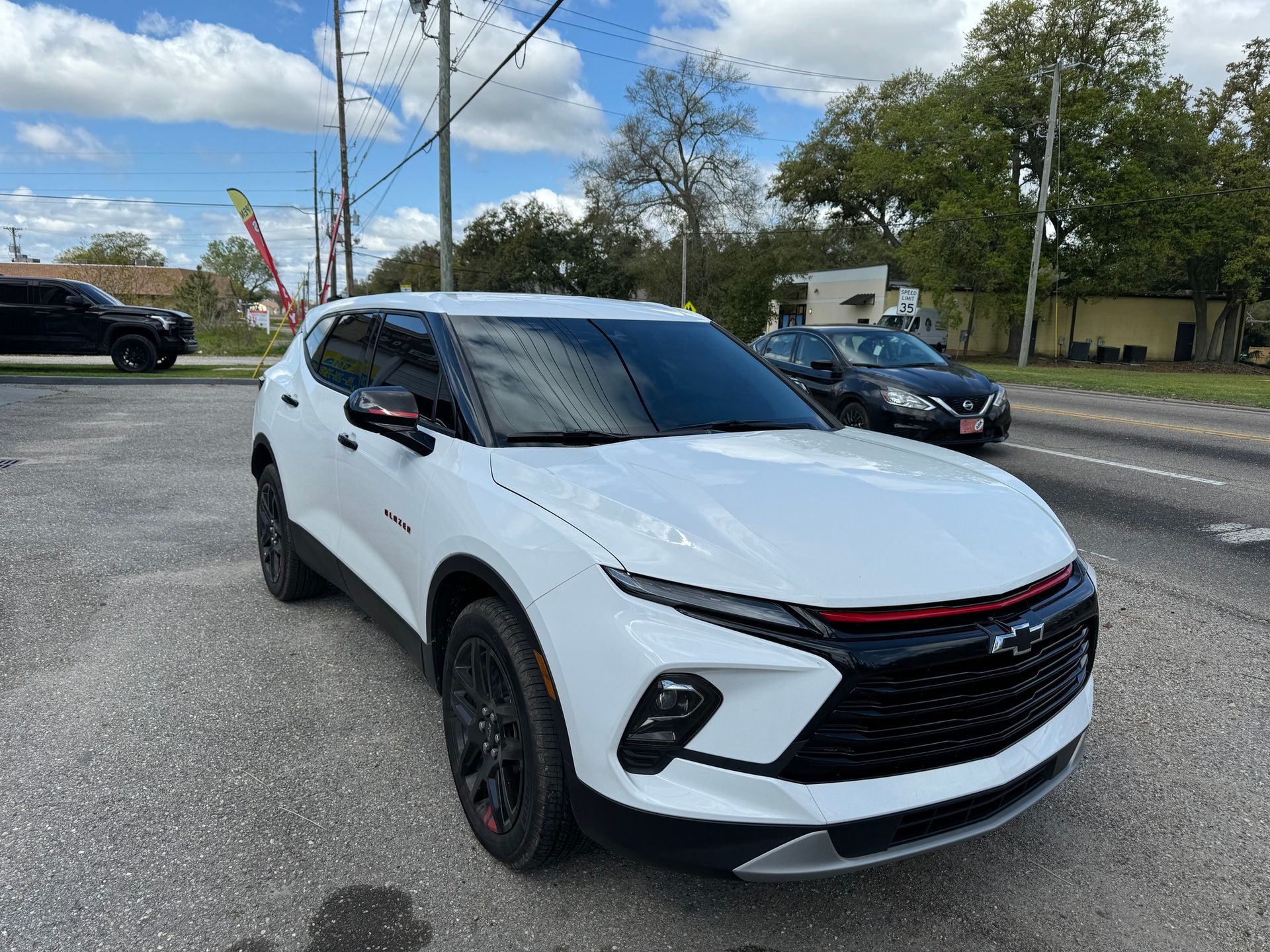 A white chevrolet blazer is parked on the side of the road.