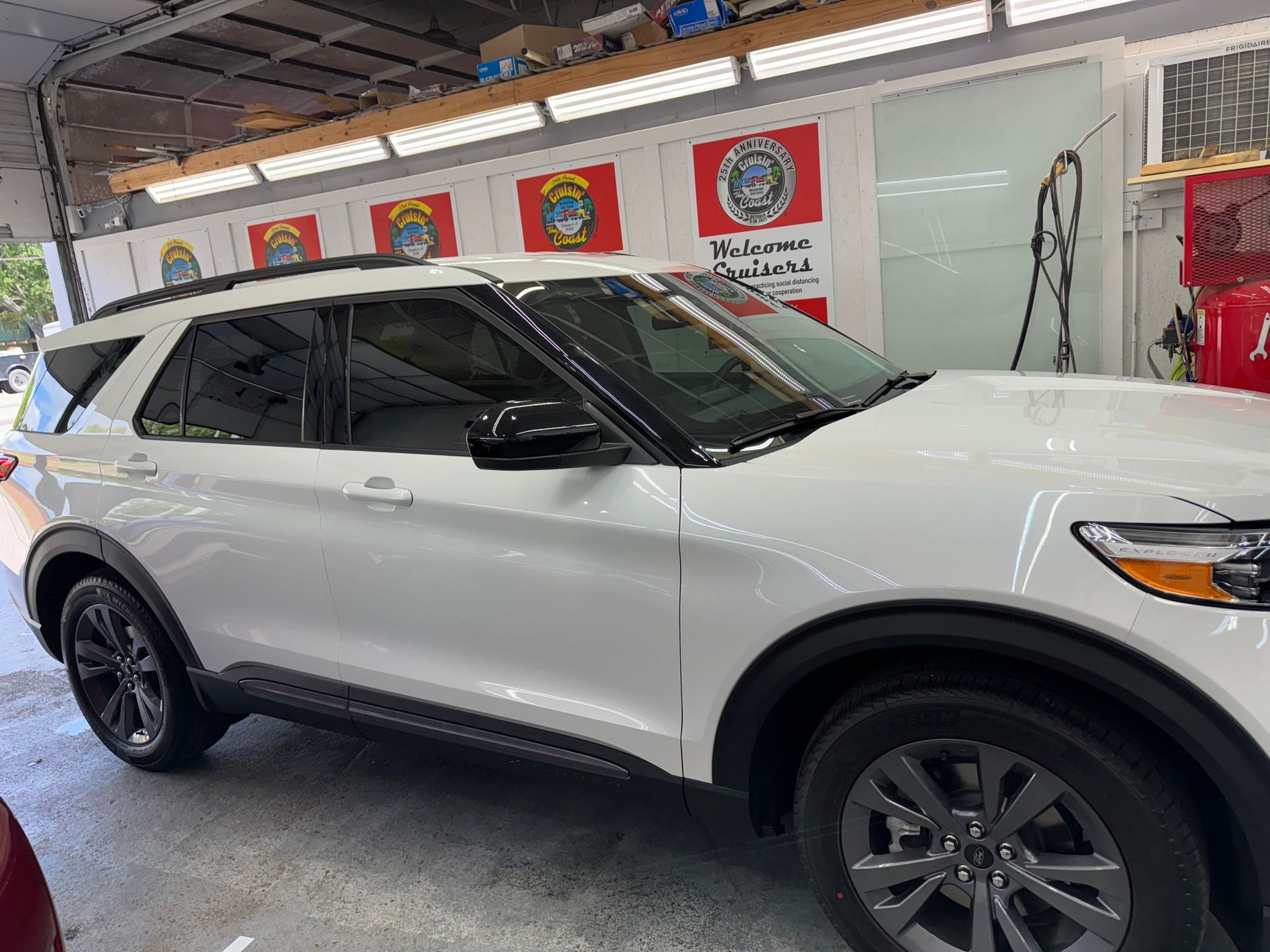 A white ford explorer is parked in a garage.