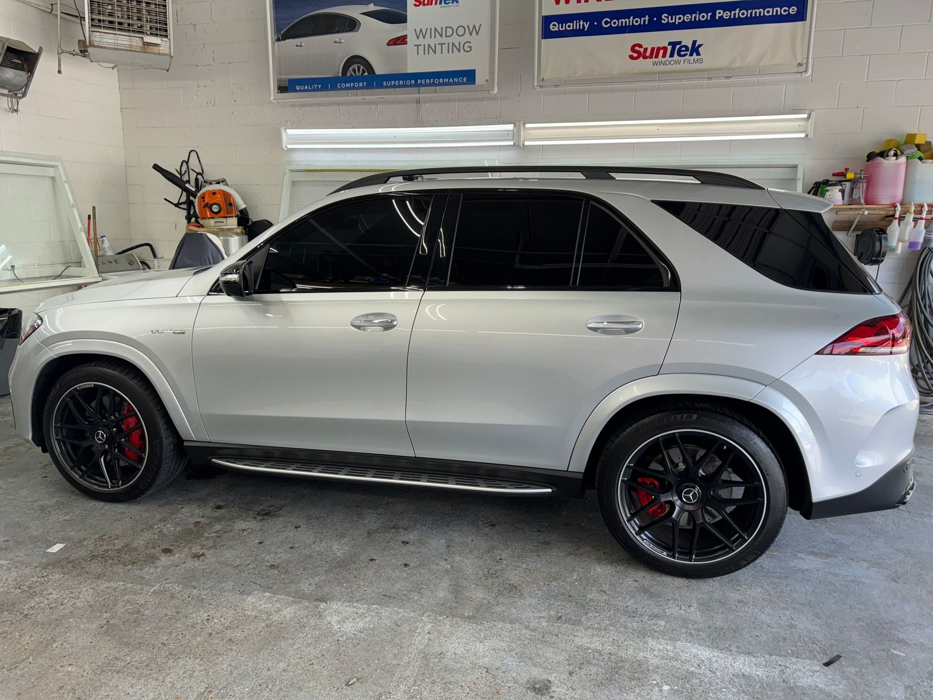 A white suv is parked in a garage.