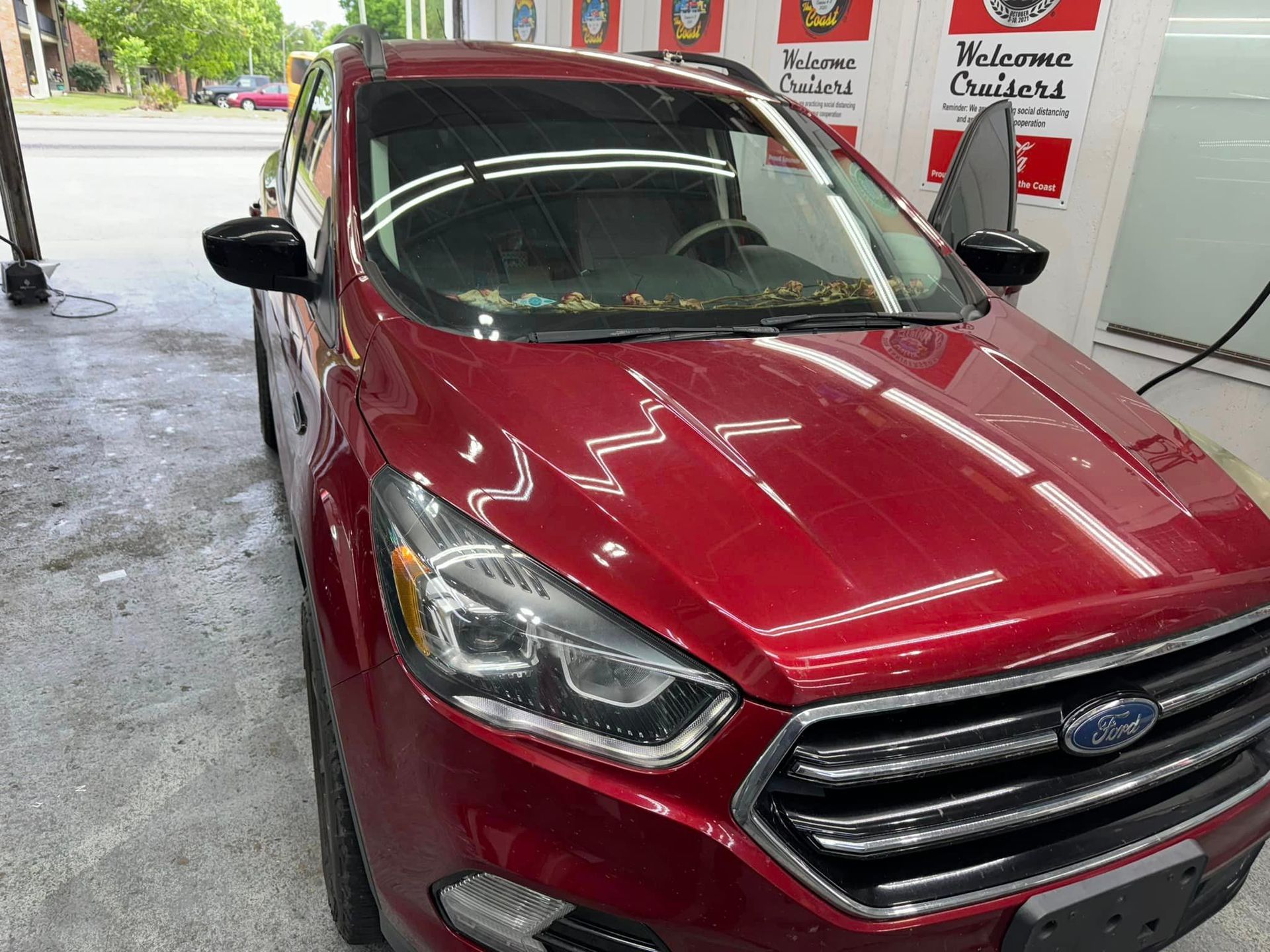 A red ford escape is parked in a car wash