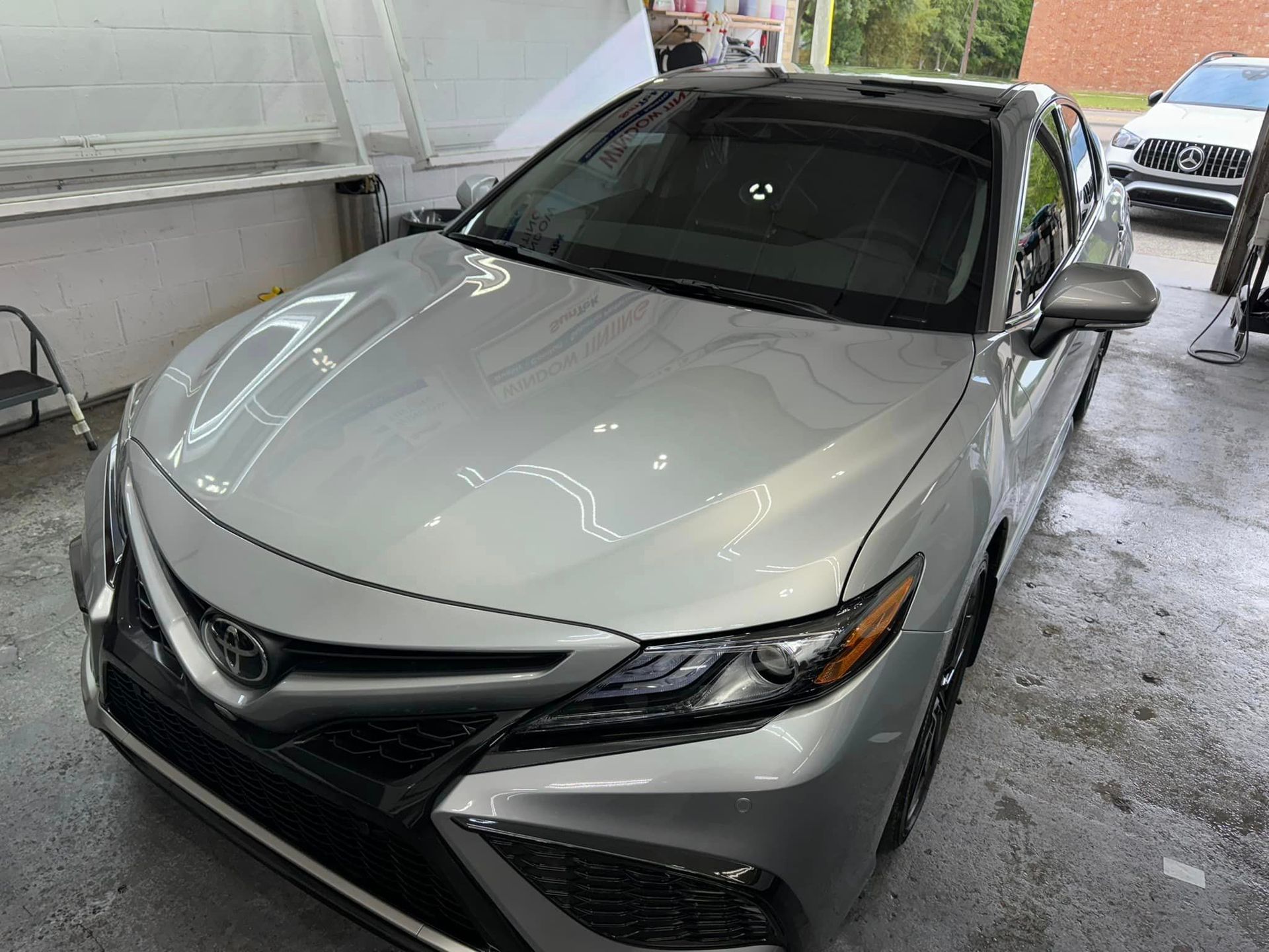A silver toyota camry is parked in a garage.