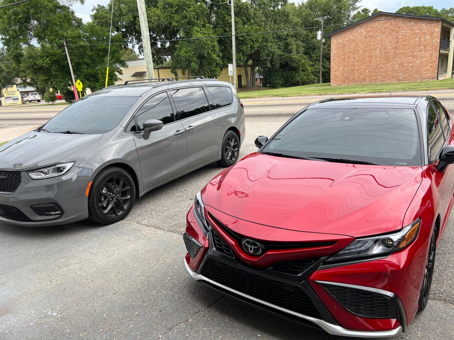 Two cars are parked next to each other on the side of the road.