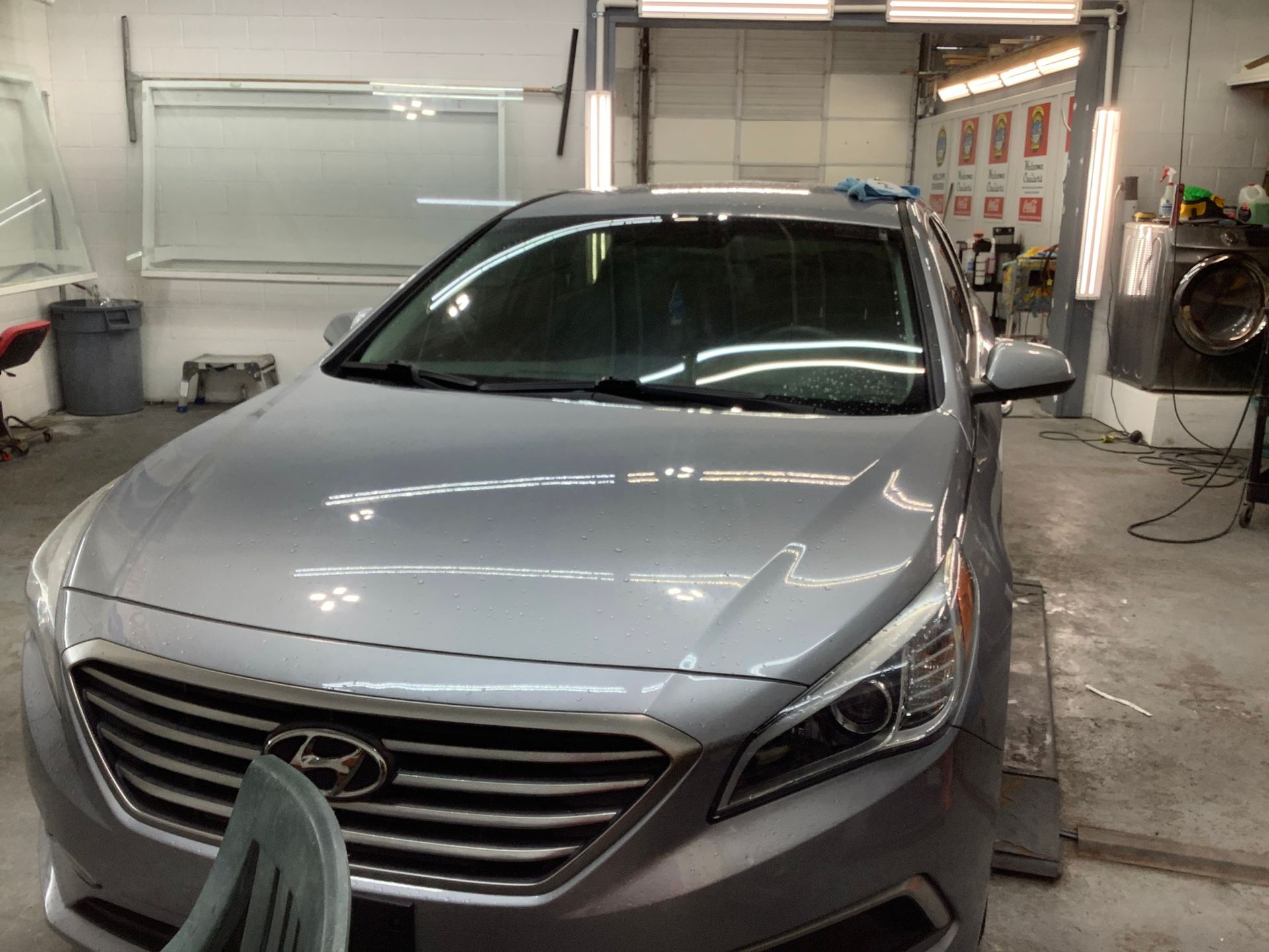 A silver hyundai sonata is parked in a garage