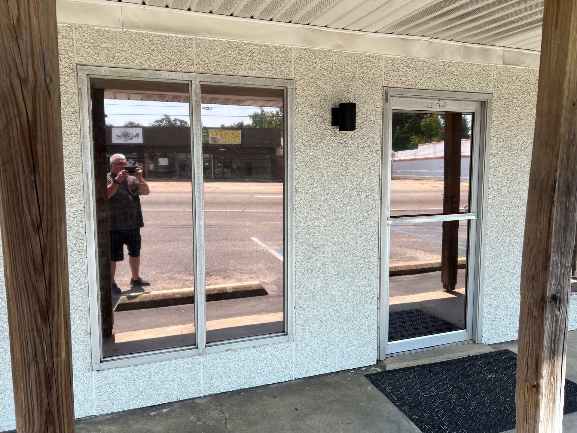 A man is taking a picture of himself in the window of a building.