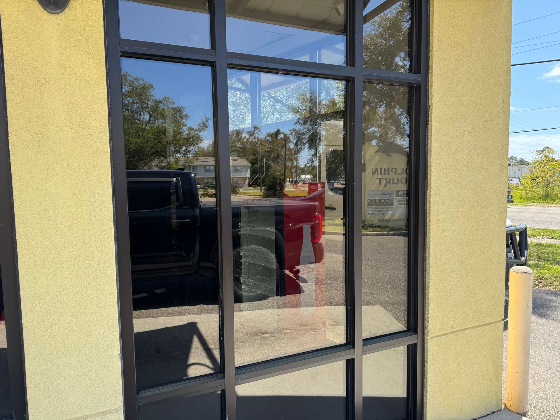 A car is reflected in a window of a building.