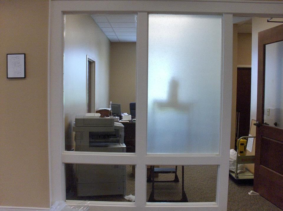 An office with a sliding glass door and a printer