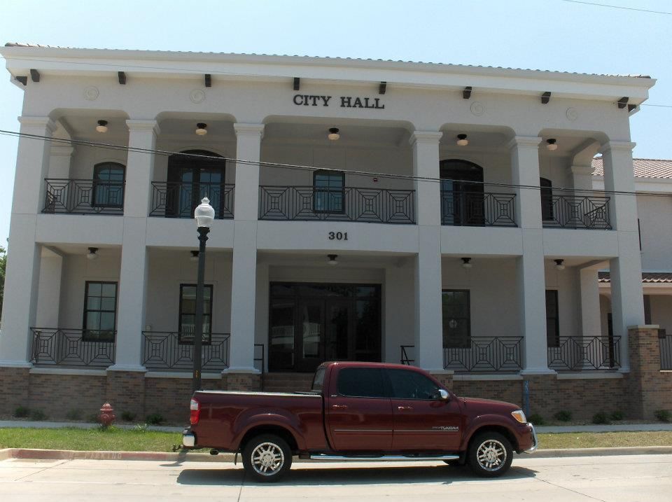 A red truck is parked in front of the city hall