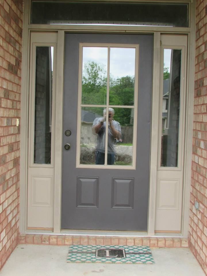A man is taking a picture of himself in front of a door