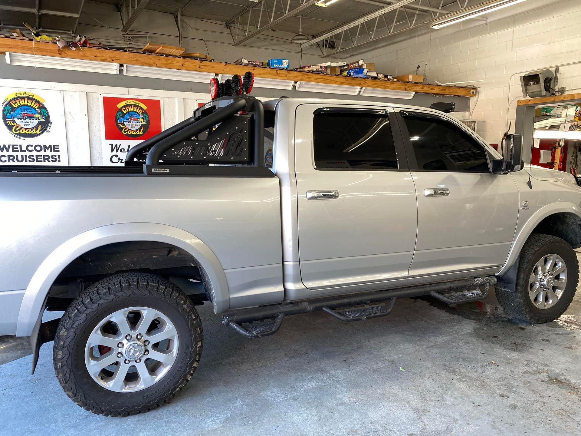 A silver pickup truck is parked in a garage.