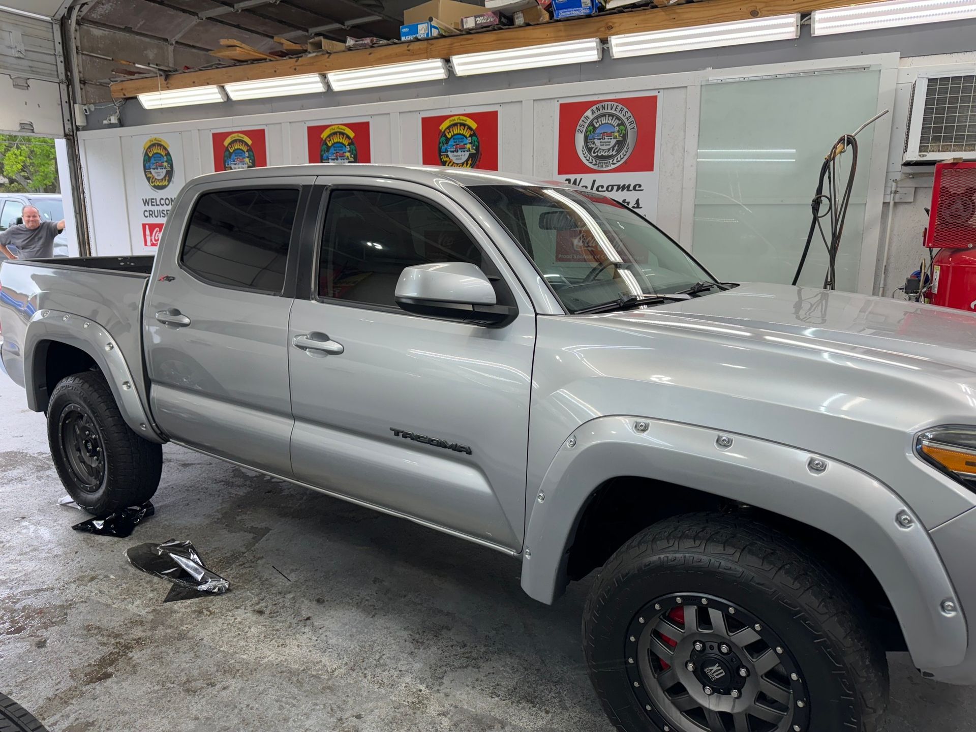 A silver toyota tacoma truck is parked in a garage.