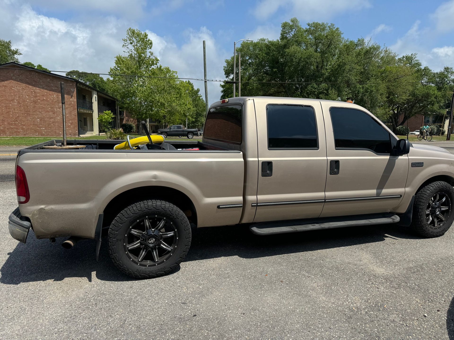A tan pickup truck is parked in a parking lot.