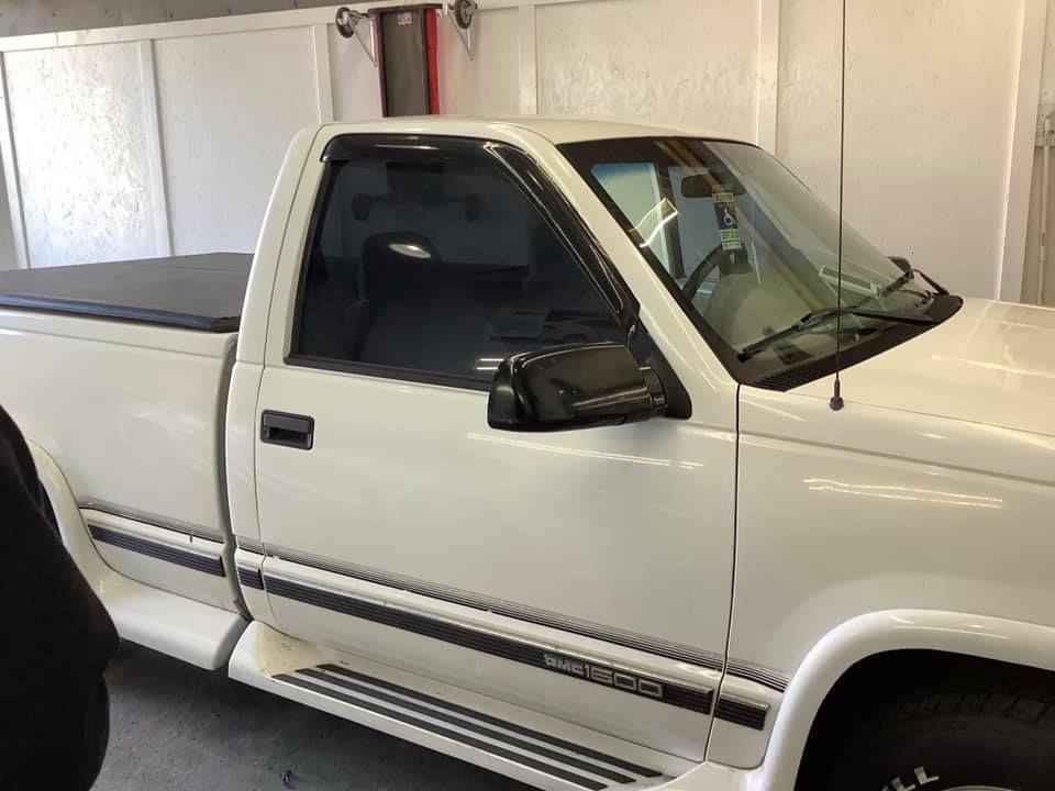 A white pickup truck is parked in a garage