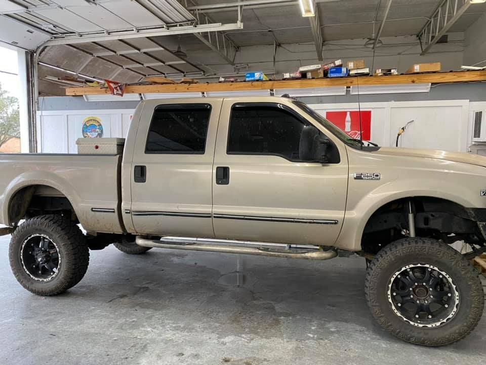 A tan pickup truck is parked in a garage.