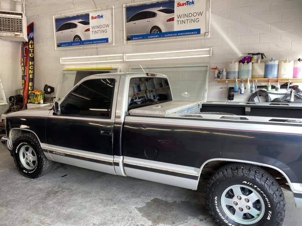 A black and white truck is parked in a garage.