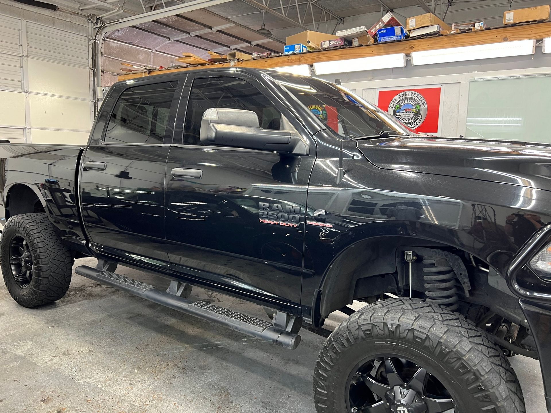 A black dodge ram truck is parked in a garage.