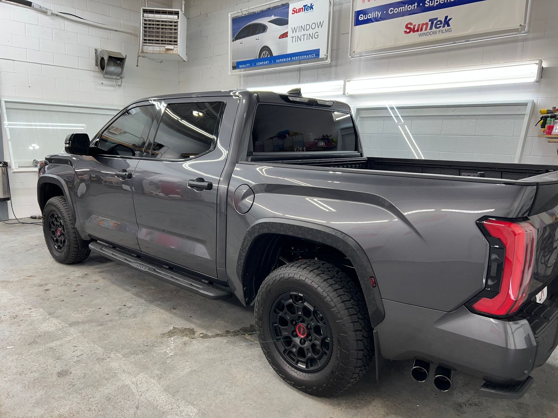 A gray truck is parked in a garage.