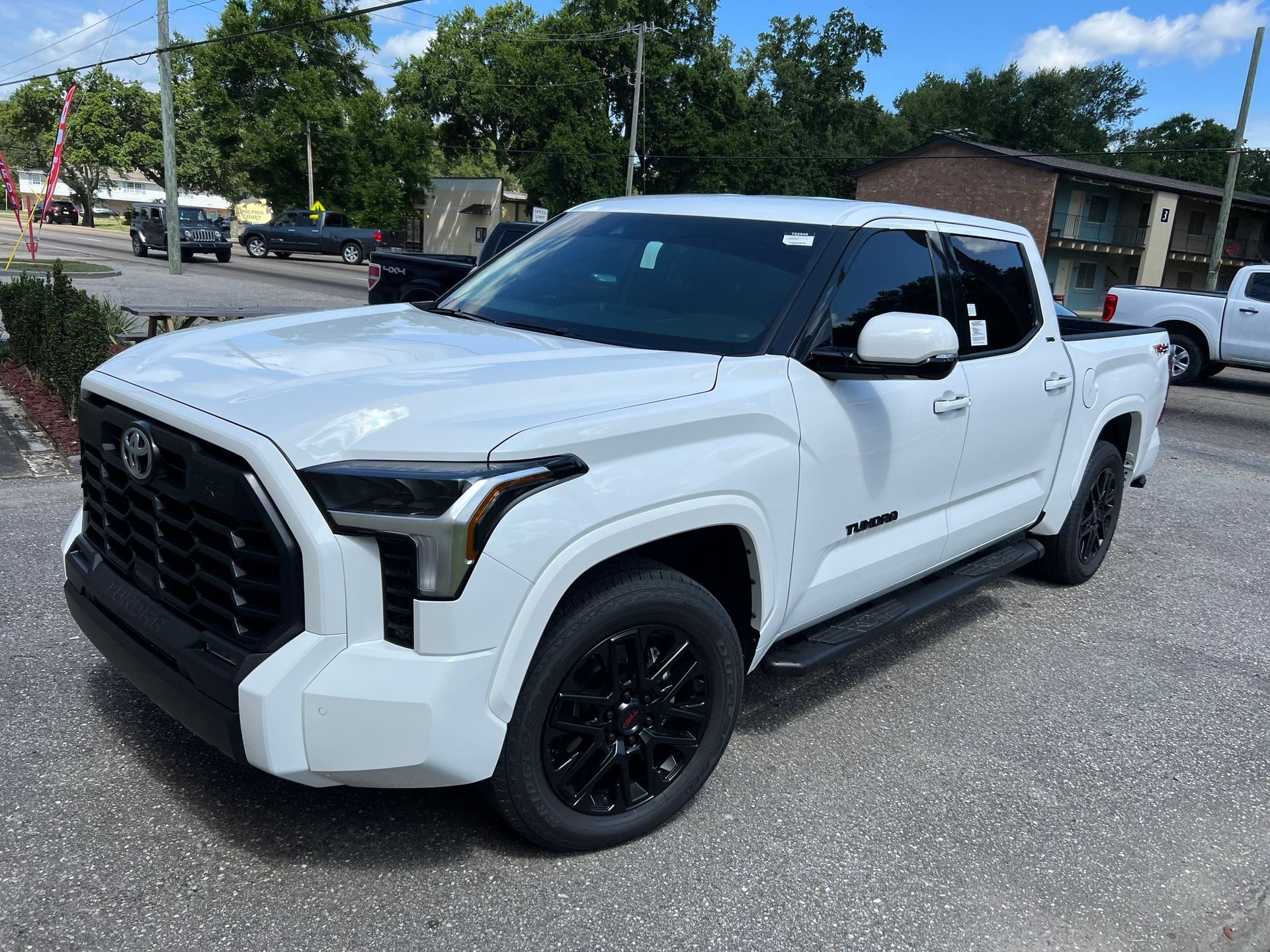 A white toyota tundra is parked on the side of the road.
