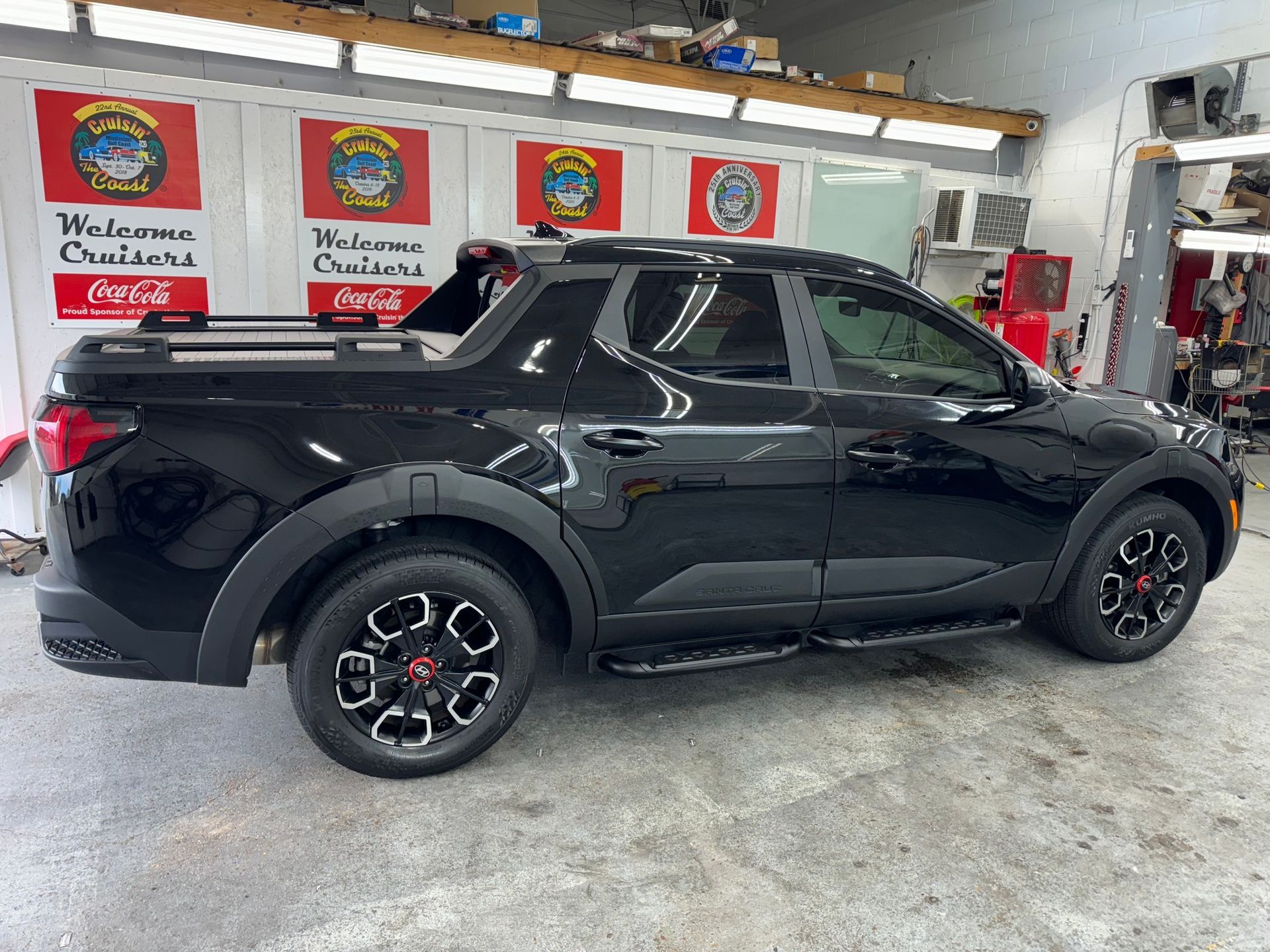 A black pickup truck is parked in a garage.