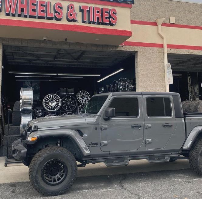 A jeep is parked in front of A J Wheels & Tires