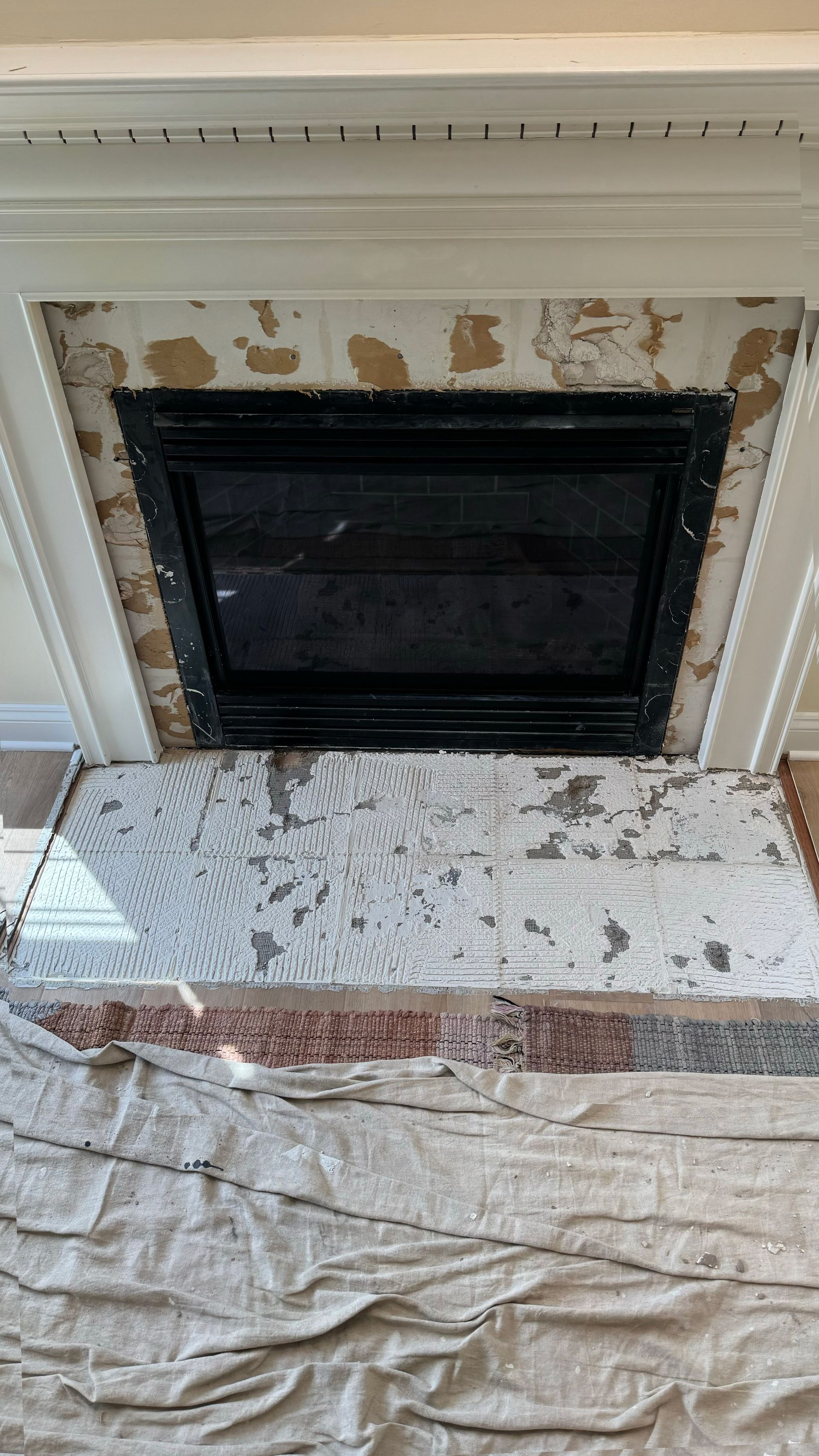 A fireplace is being painted in a living room.