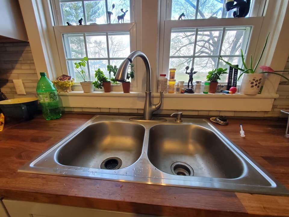 a kitchen sink is sitting on a wooden counter next to a window