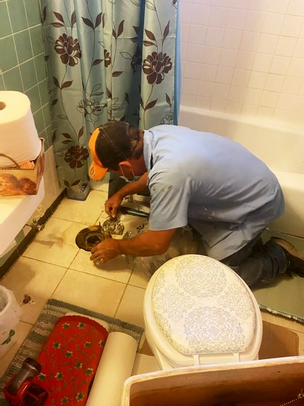 a man is working on a toilet in a bathroom