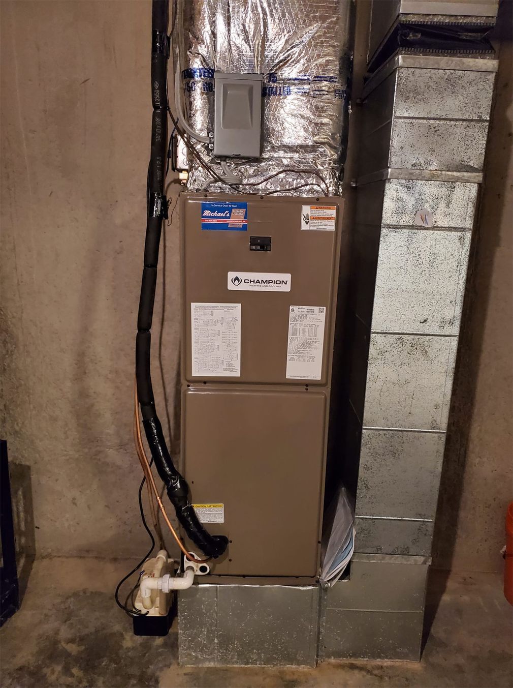 a furnace is sitting in a basement next to a brick wall