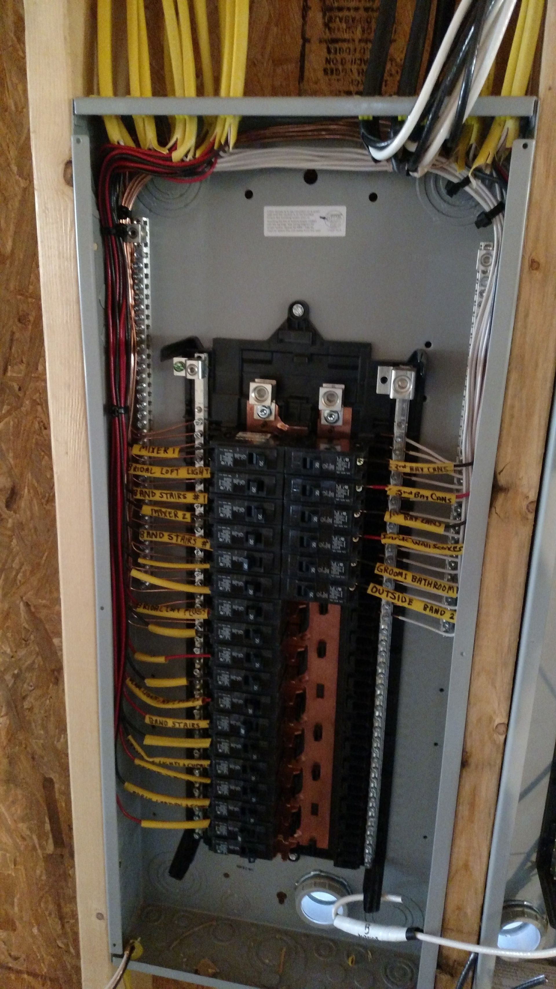 Electrical panel with numerous wires and circuit breakers installed.