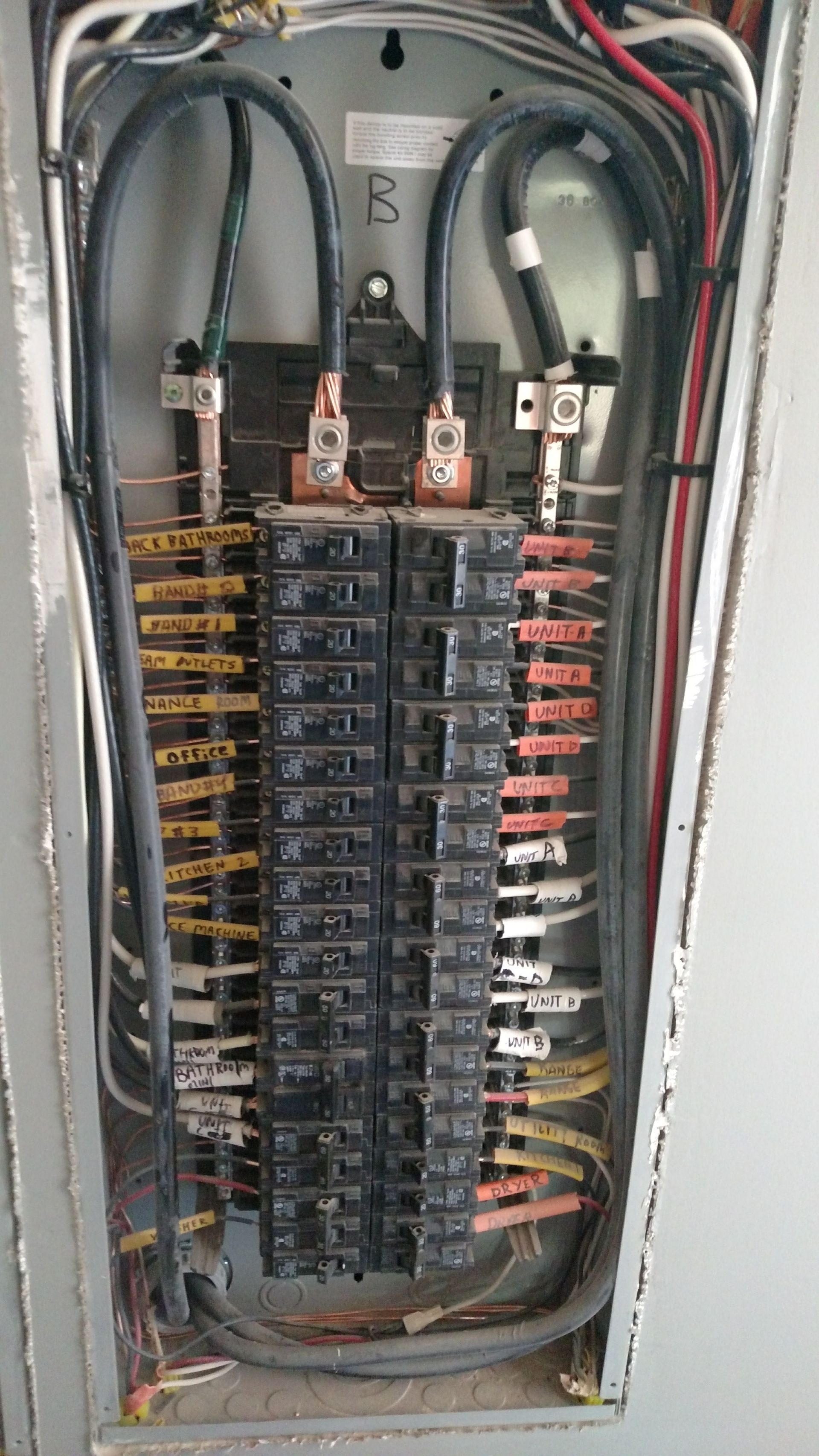 Electrical panel with rows of circuit breakers and wiring.