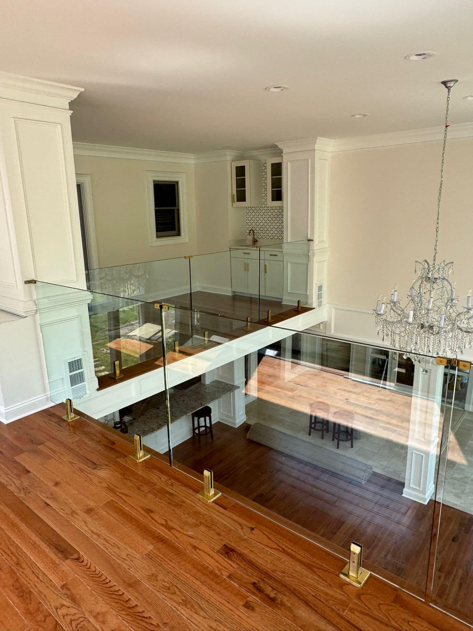 An aerial view of a living room with hardwood floors and a glass railing.
