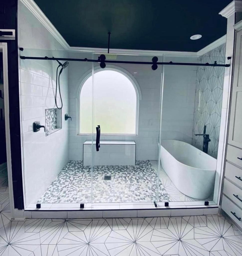 A bathroom with a tub , shower , and window.