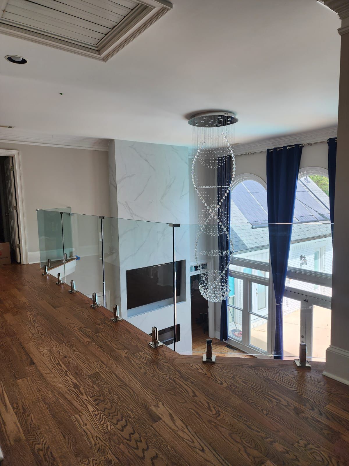 There is a glass railing on the stairs in the middle of the room.